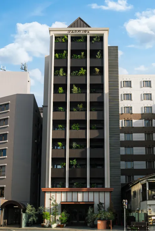 縦ラインのデザインが印象的な、モダンなホテル建物の外観。